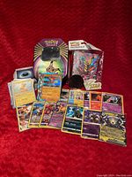 Photo showing the Pokémon TCG collector's tin, the mini binder featuring Pokémon art, and a spread of rare and holo cards including VSTAR cards.