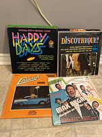 Four vintage vinyl records displayed on floor including Happy Days, Discotheque!, Cruisin' 1956, and Max Bygraves albums.