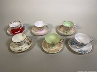 Front angled view of all six porcelain bone china teacup and saucer sets arranged in two rows