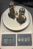 Salt and pepper shakers on digital scale showing combined weight of 101.5 grams.