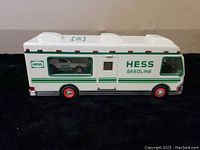 White and green 1998 Hess RV with visible dune buggy inside window and motorcycle inside.