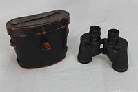 Full view of binoculars and leather carrying case, showing overall condition and style.