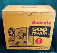 Original cardboard box labeled 'Brownie 500 Movie Projector 8mm' from Kodak in yellow and black color.