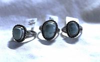 Three sterling silver rings with Southwestern and Native American style turquoise stones and twisted rope borders displayed on a white background