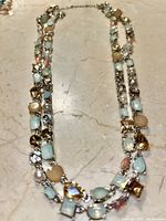 Close-up photo of the double-strand multi-stone necklace showing varied shapes and colors of stones set in silver-tone metal.