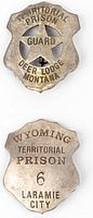 Front view of Territorial Prison Guard Deer Lodge Montana badge and Wyoming Territorial Prison 6 Laramie City badge, showing engraved text and star cutouts.