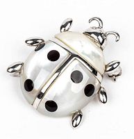 Front view of Louis Stern sterling silver and mother of pearl ladybug pendant/pin with black spots, showing overall design and materials.