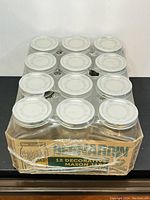 Set of 12 Bernardin decorative mason jars in original box and shrink-wrap, viewed from front showing label and jars.