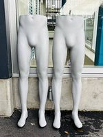 Front view of two lower male mannequins showing legs and lower torso, positioned standing side by side.