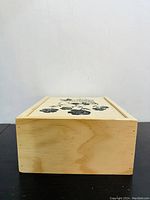 Closed wooden box showcasing the floral design on the lid and the natural wood finish on the sides