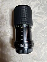 Side view of the black textured Vivitar 80-200mm zoom lens showing the zoom ring, focus scale, and aperture ring with marked distances and f-stops.