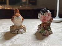 Front view of two Royal Doulton bird figurines, a wren on the left and bullfinch on the right, showing detailed painting and bases