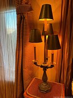 Full view of the antique bronze lamp with four black shades, showing overall design and condition.