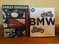 Two hardcover motorcycle books side by side, one on Harley-Davidson and one on BMW motorcycles.