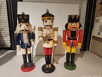 Front view of three nutcracker figurines showing detailed colorful costumes and facial expressions