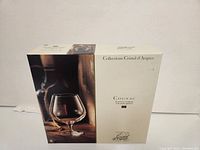 Cream-colored box with product branding and image of a single Cognac glass on front.