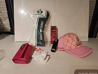 Wide shot showing Golf Ontario fairway wood head cover, pink women's golf hat, socks, golf ball box and pink organizer wallet