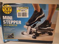 Box featuring brand logo and usage details including features of low-impact workout and targeted muscles, with image of person using stepper.
