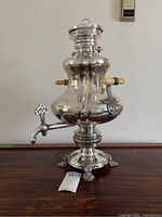 Front view of silver samovar urn with wood handles on wooden table