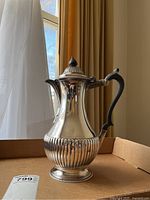 Front perspective of the coffee pot showing overall body shape, fluting and pedestal foot
