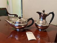 Both teapot and coffee pot side by side on table with lot number visible