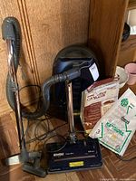 Blue Kenmore Power-Mate canister vacuum with hose, wand, and floor head, accompanied by vacuum bags in packaging.