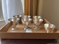 All seven bowls arranged on cardboard tray—six large, one small