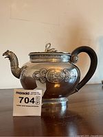 Full view of teapot showing body, handle and figural spout