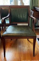 Front view of armchair showing vinyl seat and back with nailhead trim