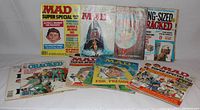 Front view of 10 MAD magazines and 1 CRACKED magazine laid out on white background.