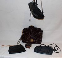 Overview of four purses and one belt on white backdrop