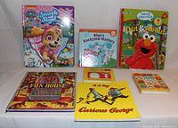 Front view of all 7 children's books displayed upright and flat on white background showing covers