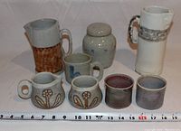 All nine pottery pieces arranged together showing various designs and sizes