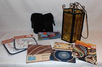 Photo showing antique-style decorative lantern light with amber glass panels, black wrist braces, kitchen-themed pot holders, and Aboriginal-style decorative hot plates.