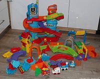 Full view of all pieces in the Chug & Go Smart Wheels train and car set arranged on floor