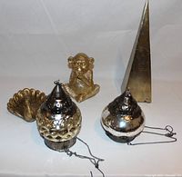 Lot contents showing brass monkey figurine, tapered brass obelisk, brass peacock figurine and two hanging metal lantern-style ornaments