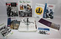 Wide view of all included war books and pamphlets arranged on table.