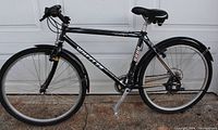 Black Wheeler mountain bike with straight handlebars, padded seat, front and rear fenders, and multiple gears.