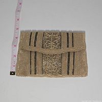 Top view of antique beaded evening clutch showing gold and black beaded floral motif with ruler for size reference (4 inches).