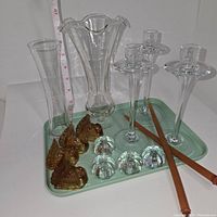Four tall clear glass candlesticks, two clear glass vases, amber glass turkey figurines, and clear glass pumpkin figurines on a light green tray.