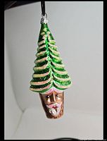 Front view of the pine tree Santa glass ornament showing the detailed Santa face and green pine tree branches with glitter accents.