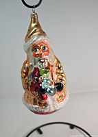 Front view of the glass Santa Claus ornament showing facial details, gifts, and coat decoration.