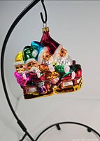 Front view of the Christopher Radko glass Christmas ornament showing four Santa Claus figures in a sleigh.