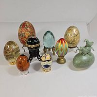 Overview of nine decorative eggs with various stands and designs
