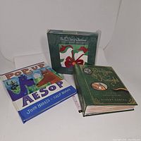 Three pop-up books in a group; Pop-Up Aesop, The 12 Days of Christmas in shrink wrap, and Dragon & Knight with decorative green cover