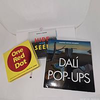 Three artistic theme pop-up books sitting side by side, covers visible