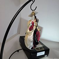 Side view of the Cruella de Vil ornament hanging above the box.