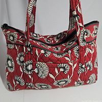 Red Vera Bradley quilted zippered tote bag with floral print, shown from front with handles visible