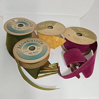 Four vintage velvet ribbons on original spools in olive green, mustard yellow, and deep magenta colors.