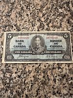 Front of 1937 Bank of Canada $5 bill with portrait of King George VI and bilingual denomination.